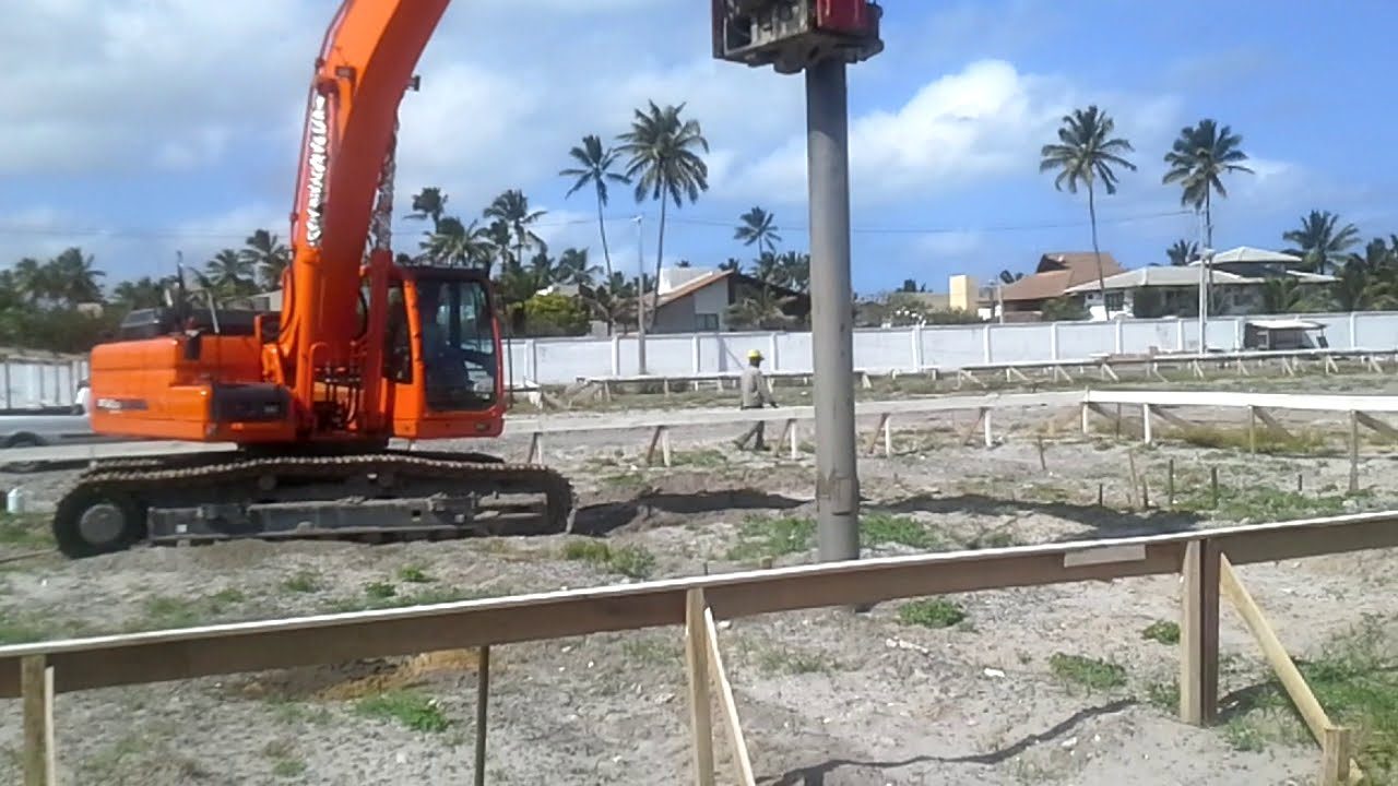 Escavadeira cravando o tubo de uma coluna de areia e brita em canteiro no litoral de Pernambuco